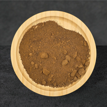 Brown powder in a wooden bowl on a dark background