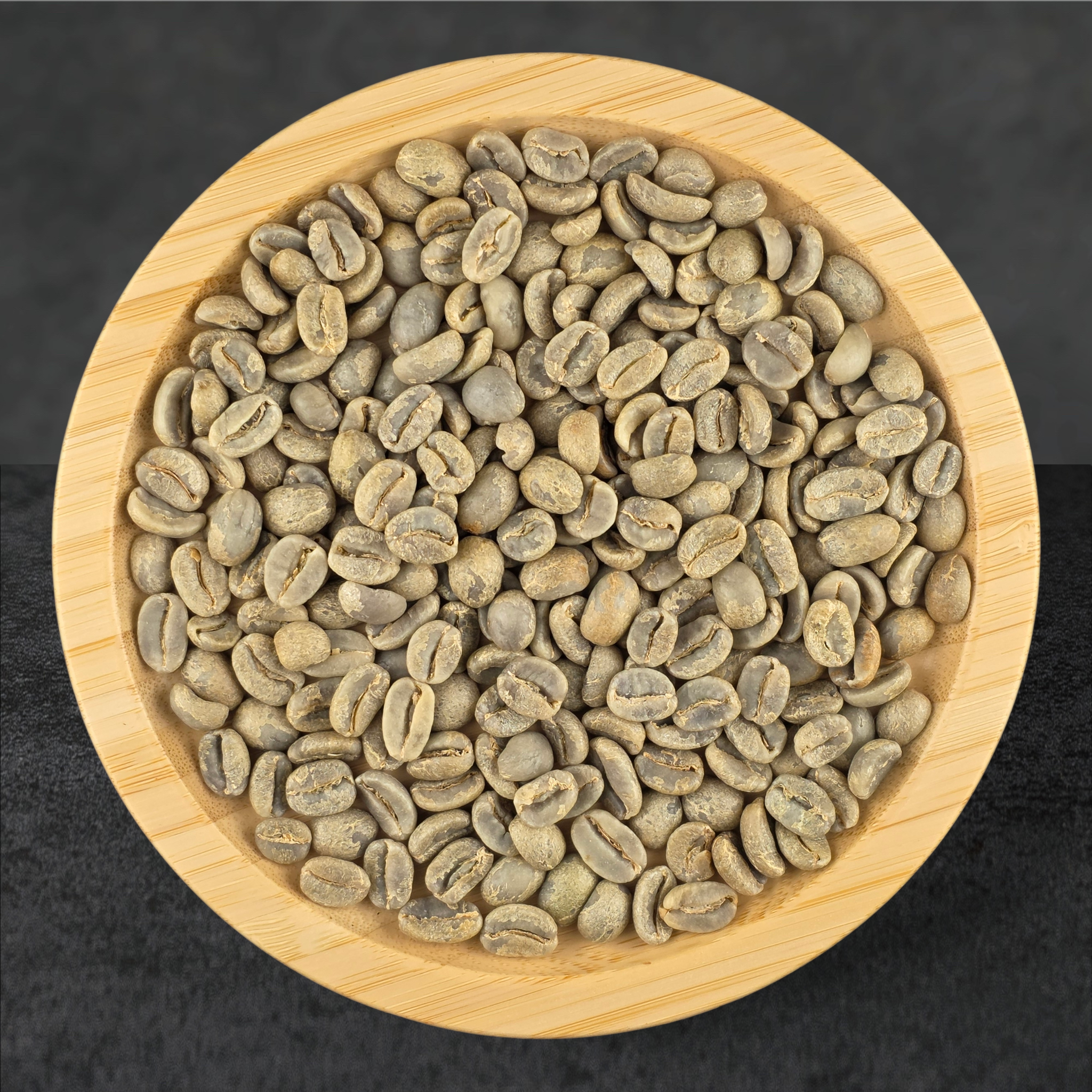 Green coffee beans in a wooden bowl on a dark background