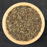 Wooden bowl filled with dried herbs on a black background