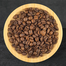 Roasted coffee beans in a wooden bowl on a dark background