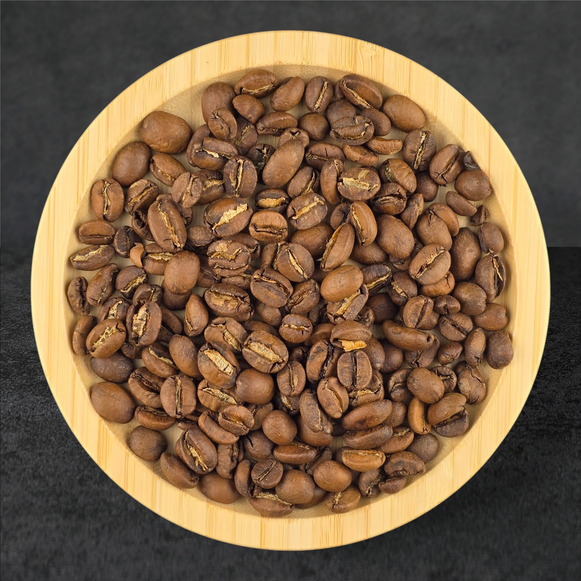 Coffee beans in a wooden bowl on a dark background